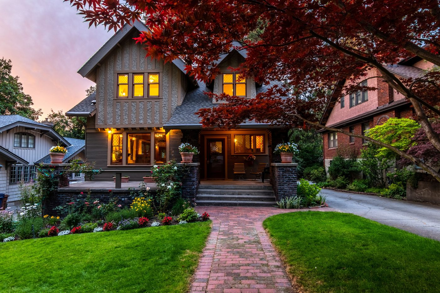 A house on a quiet, tucked-away street at dusk, windows lit